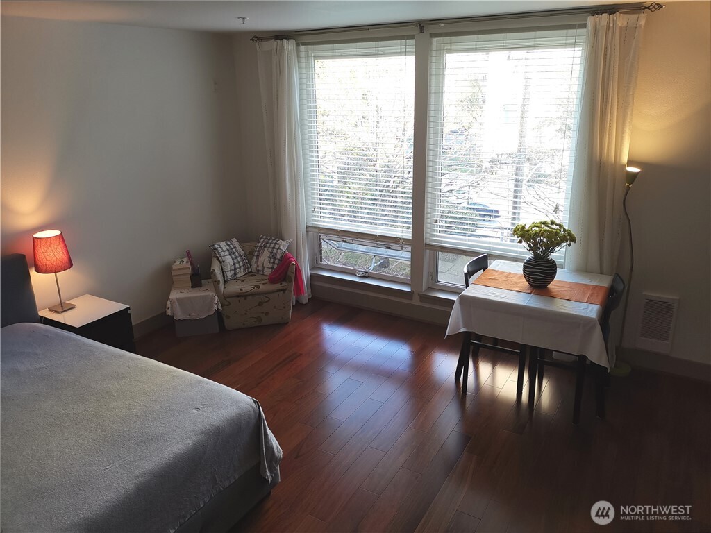 4547 8th Avenue Northeast, Unit 408 Seattle, WA 98105 - Photo 24 of 27 a bedroom with a bed and wooden floor