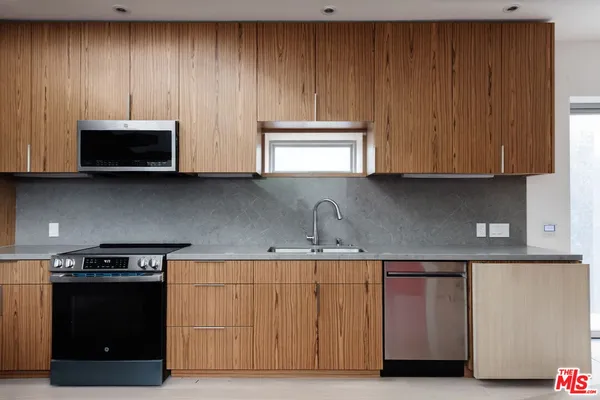 a kitchen with stainless steel appliances a stove a sink and cabinets