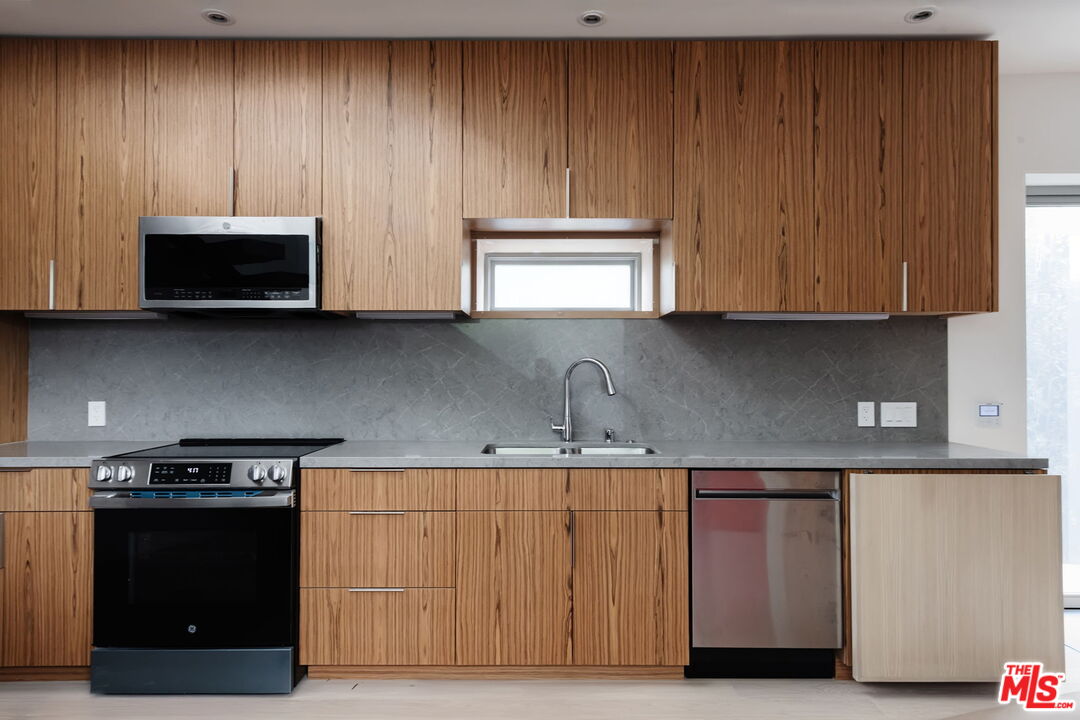 340 Indiana Avenue Venice, CA 90291 - Photo 10 of 20 a kitchen with wooden cabinets and a stove top oven
