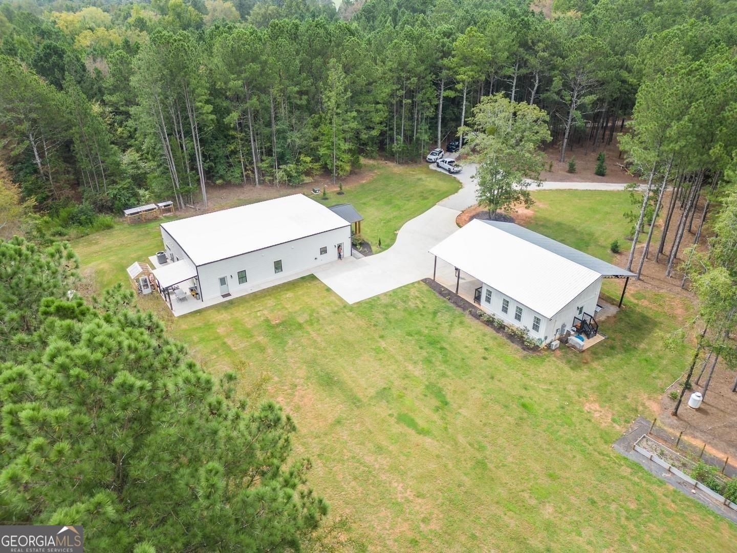 an aerial view of a house with pool and a yard
