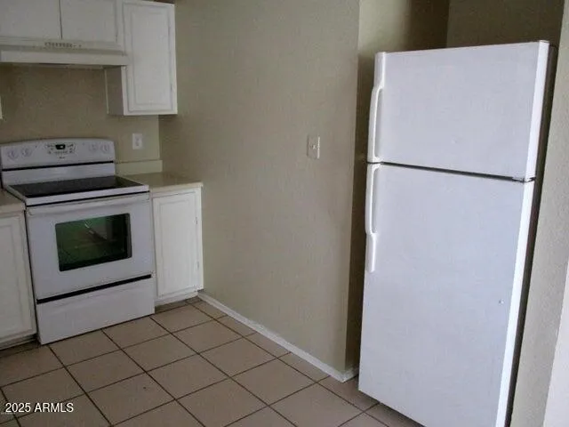a kitchen with a stove top oven and cabinets
