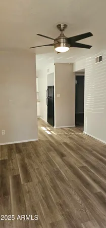 a view of a big room with wooden floor and a ceiling fan