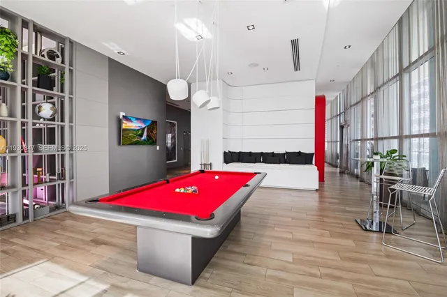 a room with lots of white furniture and wooden floor