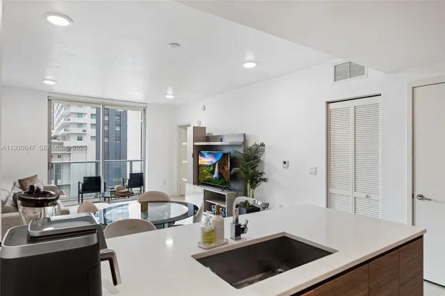 a kitchen with a sink a stove and chairs