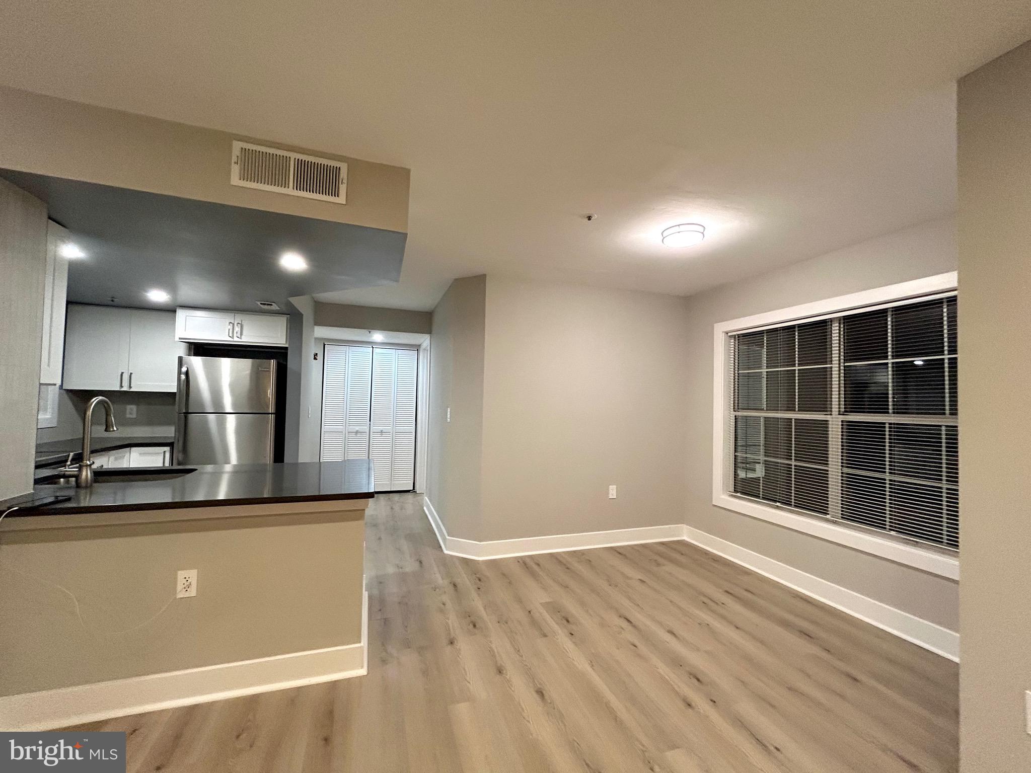 a view of a kitchen with wooden floor and kitchen space