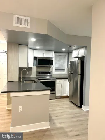 a kitchen with stainless steel appliances granite countertop a refrigerator a stove and a sink