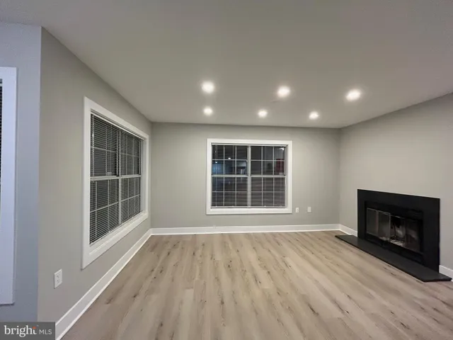 a view of an empty room with a window and fireplace