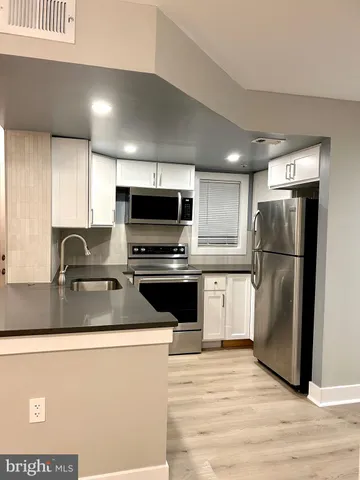 a kitchen with a refrigerator sink and stove top oven