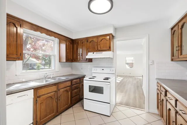 a kitchen with a stove a sink and a window