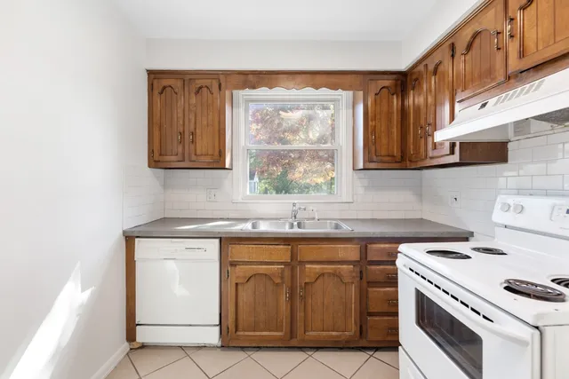 a kitchen with a stove sink and cabinets
