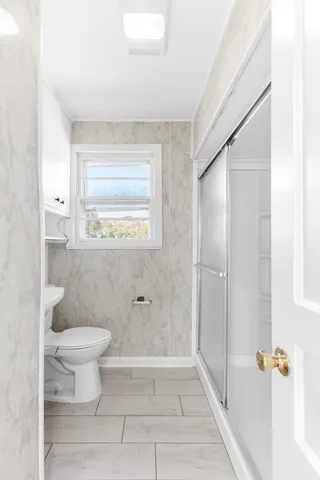 a bathroom with a toilet and a shower