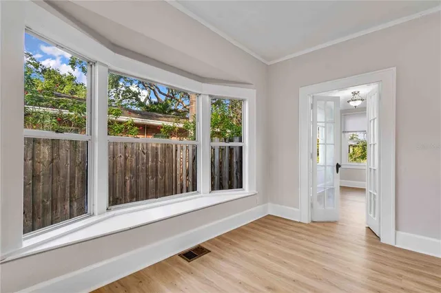 a view of an empty room with wooden floor