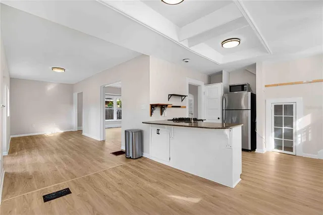a view of an empty room with wooden floor