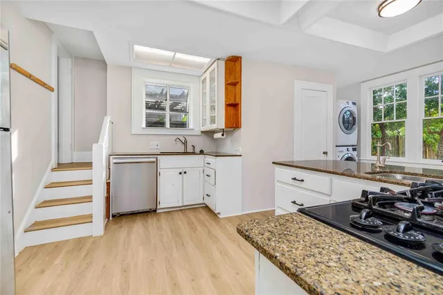 a view of a backyard with wooden fence and a large tree