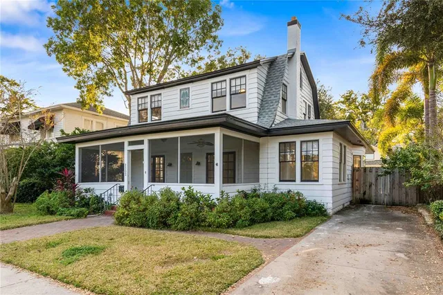 a living room with a black white checkered floor with a gaming machine and dining space