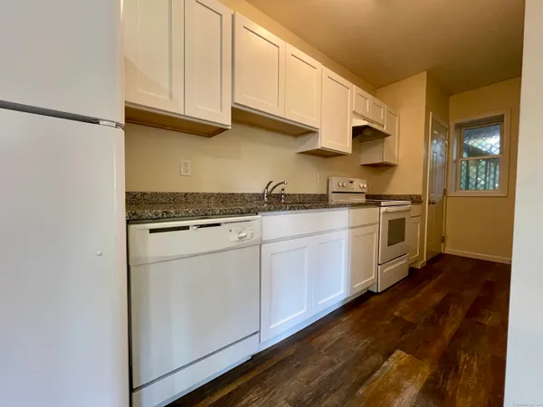 a kitchen with stainless steel appliances granite countertop a sink a stove and cabinets