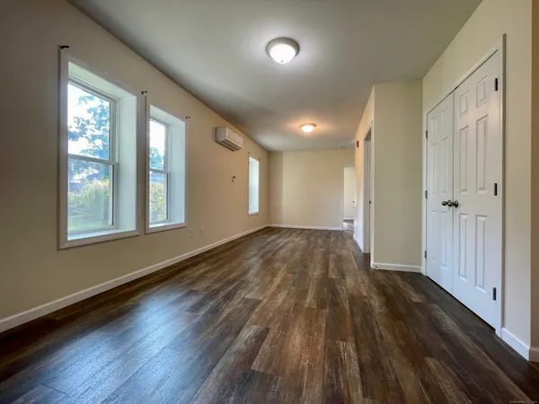 an empty room with wooden floor and windows