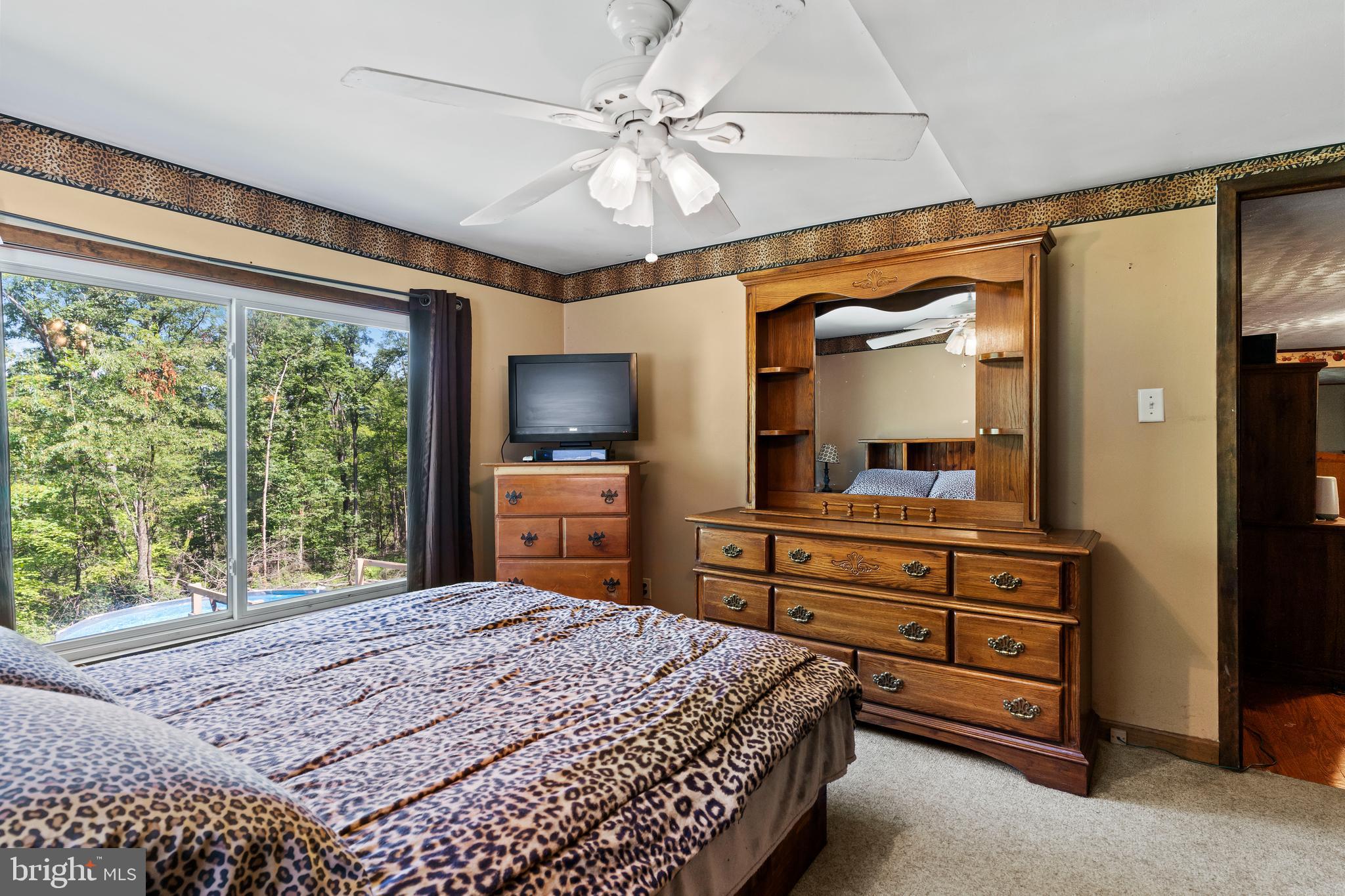 21429 Buck Trail Shade Gap, PA 17255 - Photo 12 of 42 a bedroom with a large bed and a flat tv screen on dresser