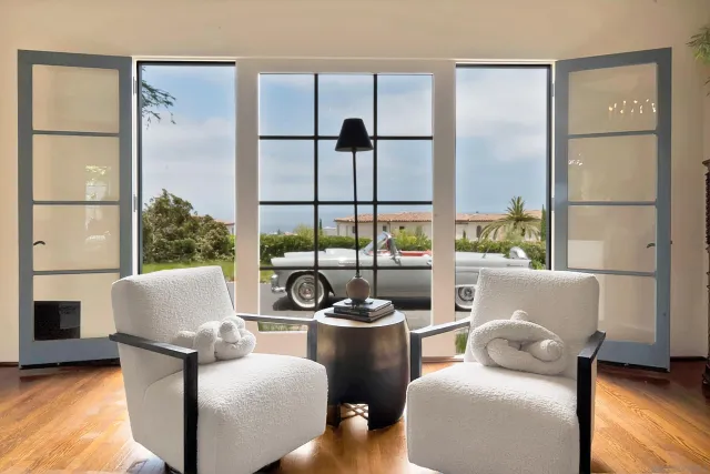 a living room with furniture a fireplace and a large window