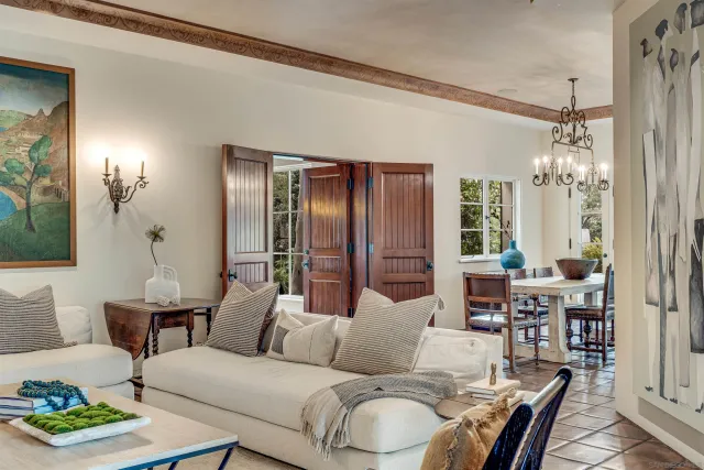 a living room with furniture a fireplace and a chandelier
