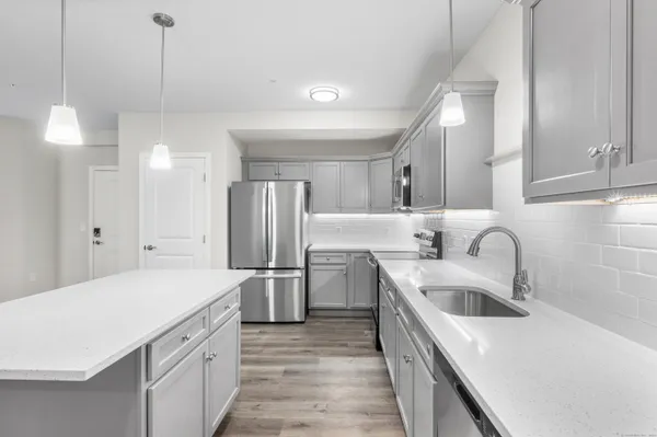 a kitchen with a sink a stove a refrigerator and cabinets
