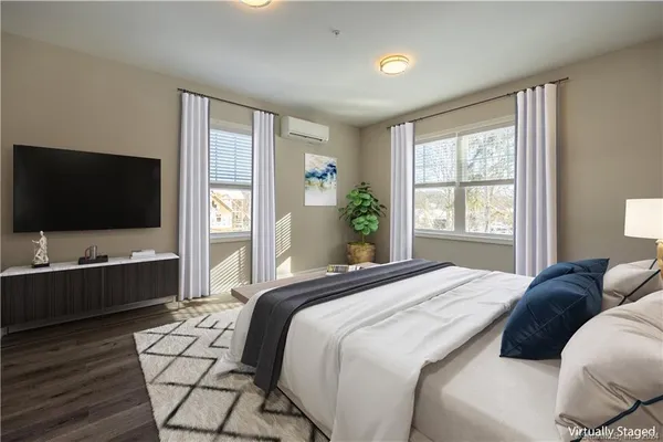 a bedroom with a bed and a flat screen tv on dresser