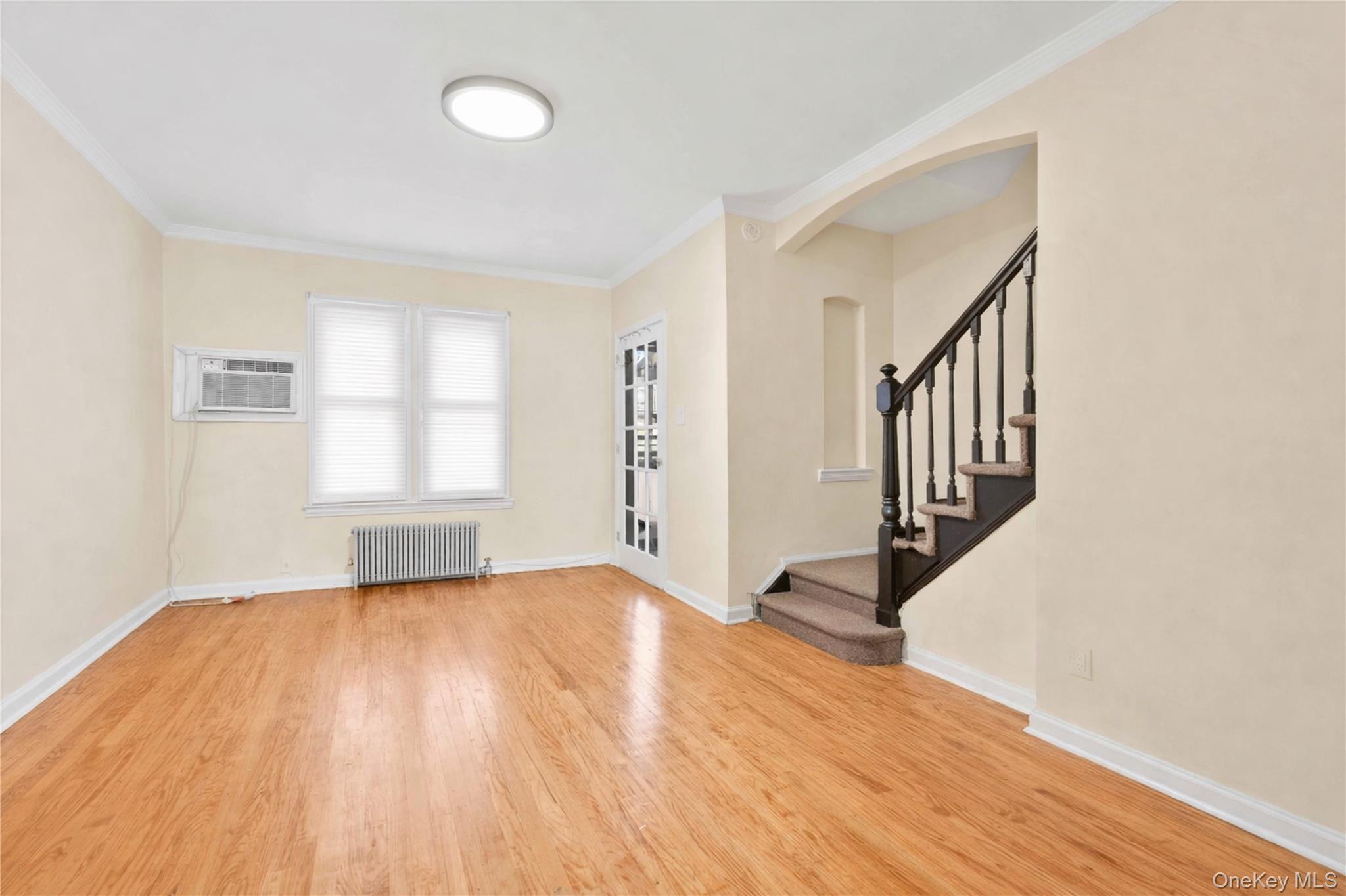 136-76 71st Road Queens, NY 11367 - Photo 13 of 31 wooden floor in an empty room with a window and wooden floor