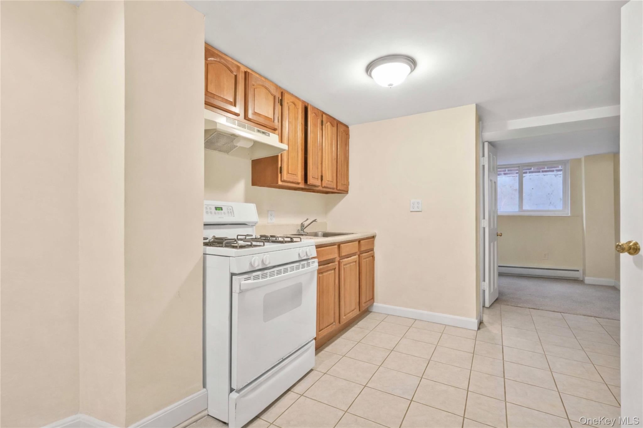 136-76 71st Road Queens, NY 11367 - Photo 26 of 31 a kitchen with a stove top oven and cabinets
