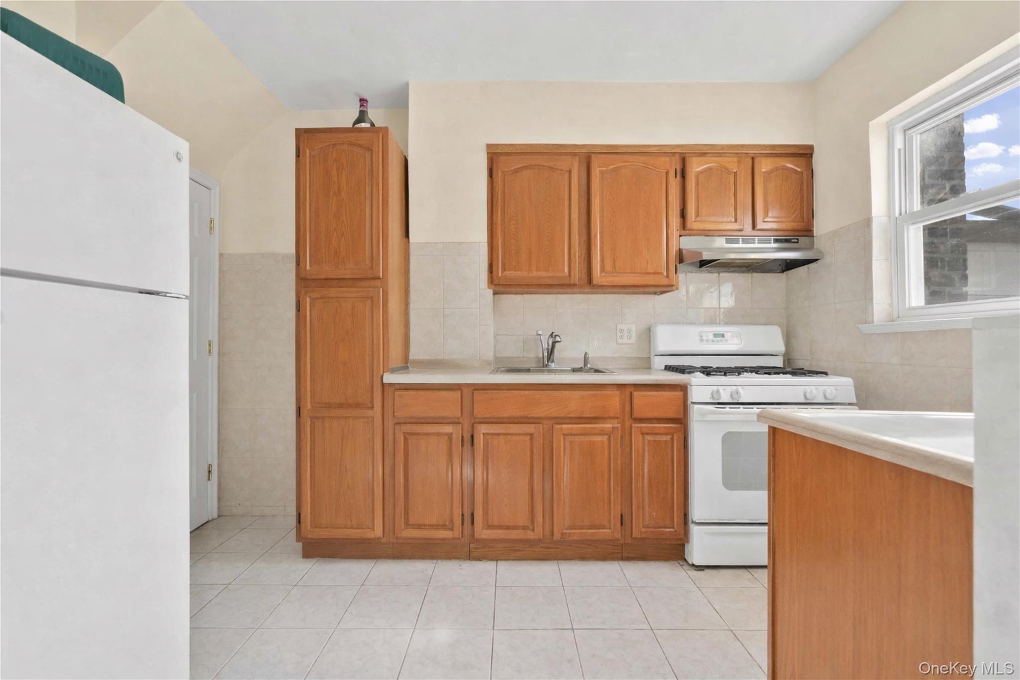 136-76 71st Road Queens, NY 11367 - Photo 6 of 31 a kitchen with stainless steel appliances granite countertop a refrigerator sink and cabinets