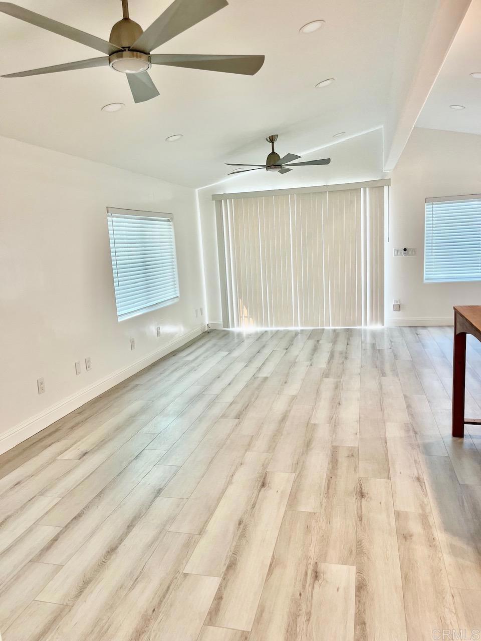 9902 Jamacha Boulevard, Unit 160 Spring Valley, CA 91977 - Photo 3 of 18 an empty room with wooden floor ceiling fan and windows
