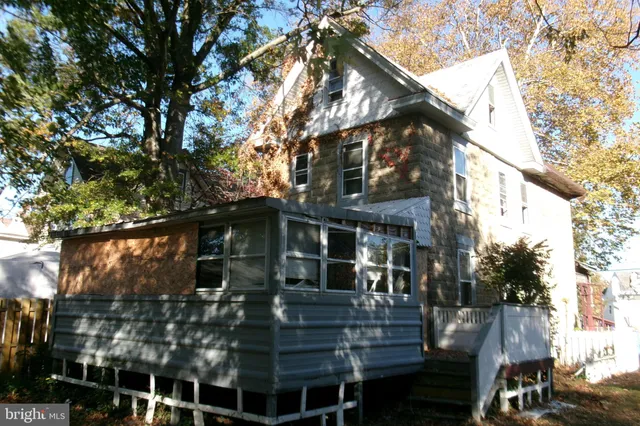 a front view of a house with a tree