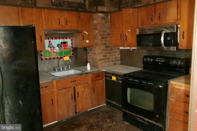 a kitchen with stainless steel appliances wooden cabinets and a stove top oven