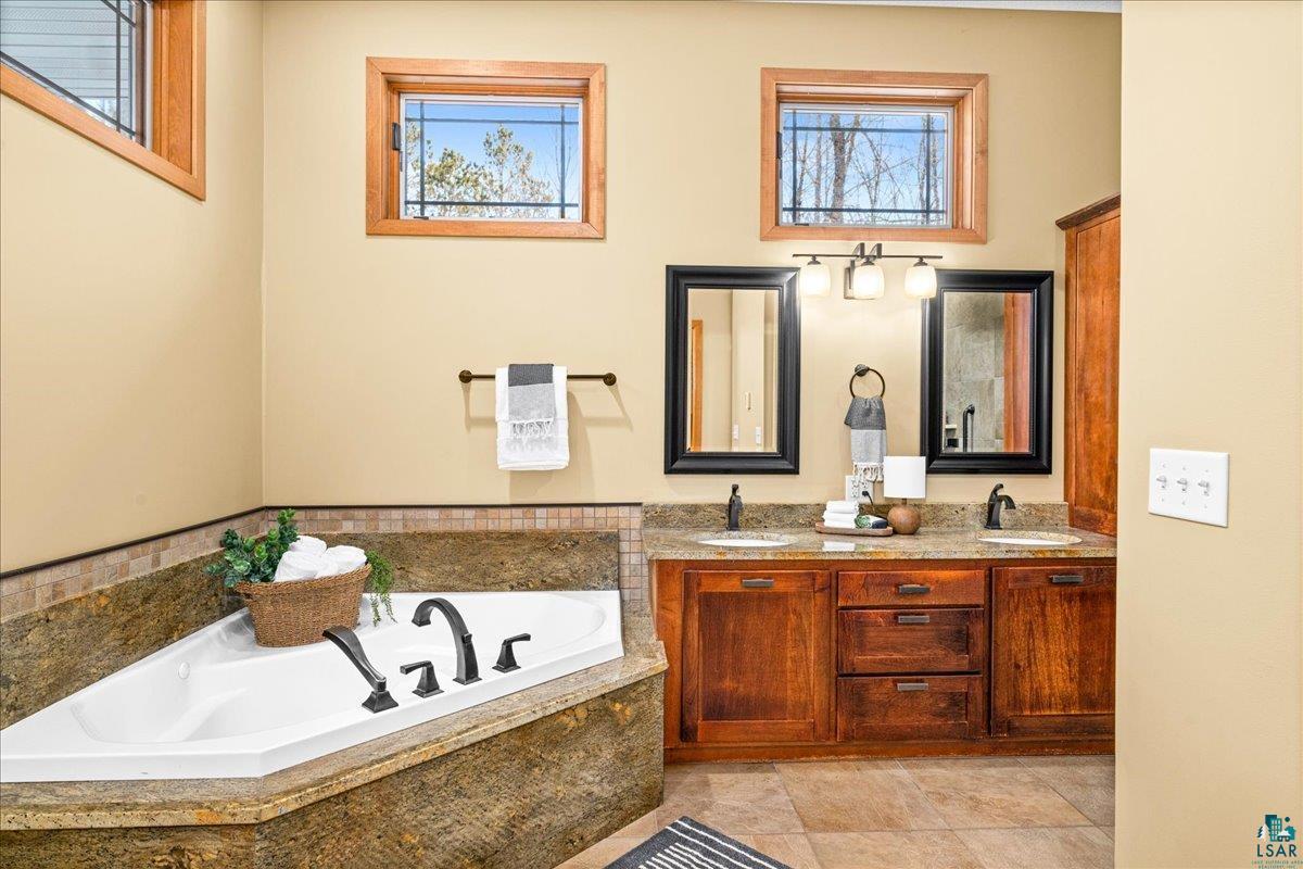 92598 Spells Road Sturgeon Lake, MN 55783 - Photo 24 of 60 Bathroom with double vanity and a garden tub