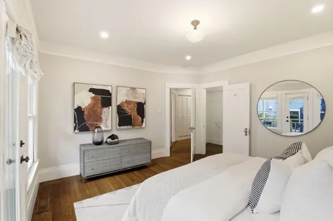 a bedroom with a large bed and a chandelier