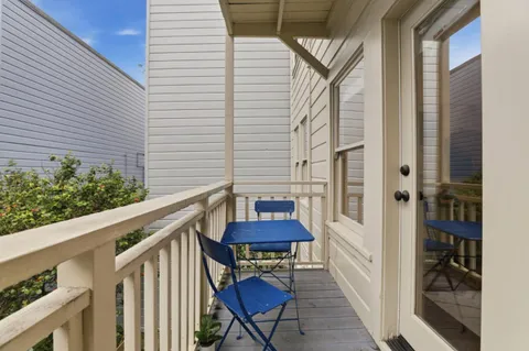 a view of a balcony with furniture and a potted plant