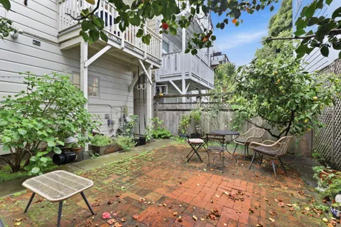 a view of a chair and table in backyard of the house