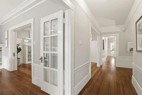 a view of a hallway with wooden floor and staircase
