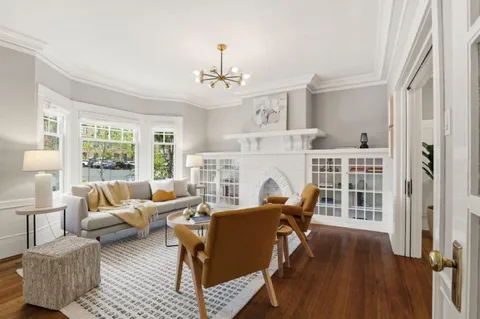 a living room with furniture a fireplace and a large window