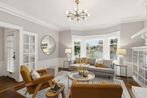 a living room with furniture kitchen view and a large window
