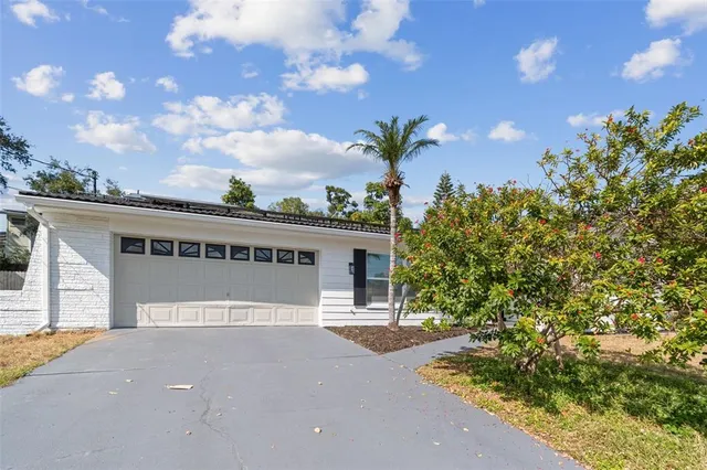 a front view of a house with a yard and potted plants