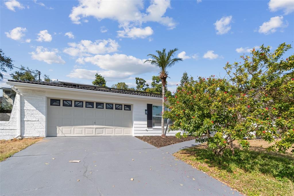 a front view of a house with a yard and potted plants