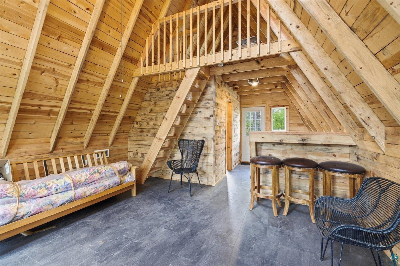 5298 Long Island Tower, MN 55790 - Photo 12 of 31 Vaulted ceiling with exposed wood beams, wood-finish flooring, built-in bar, and a loft area with wood railing