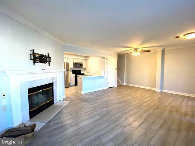 a view of a livingroom with a fireplace a chandelier and wooden floor
