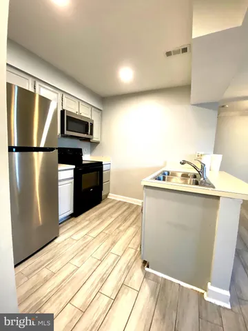 a kitchen with a refrigerator and a stove top oven