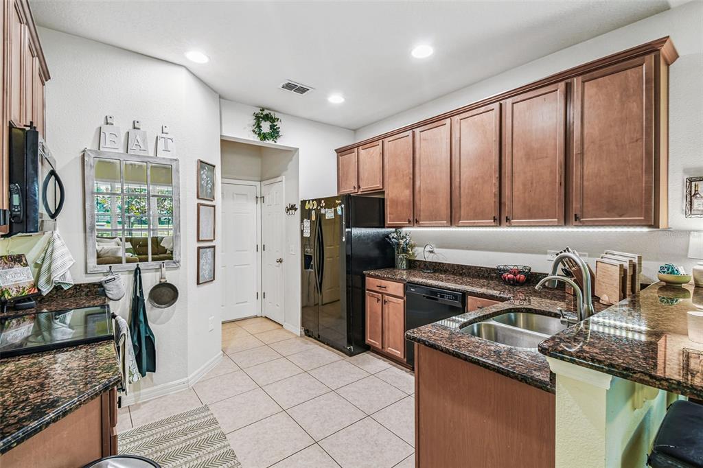 10624 Reams Road Windermere, FL 34786 - Photo 11 of 61 a kitchen with stainless steel appliances granite countertop a refrigerator a sink a stove and white cabinets