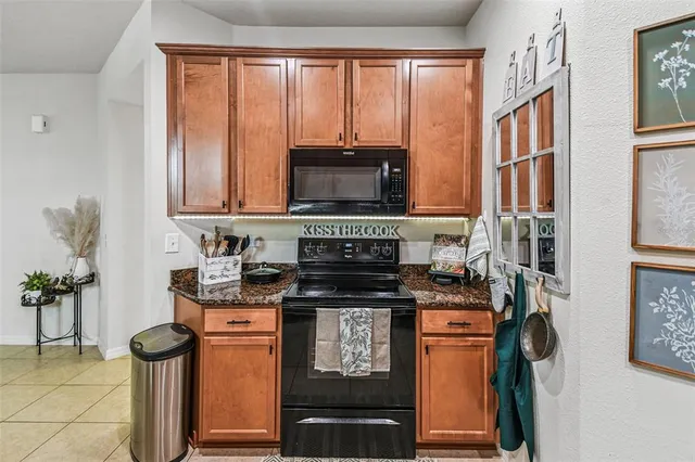 a kitchen with stainless steel appliances granite countertop a stove a sink and a microwave
