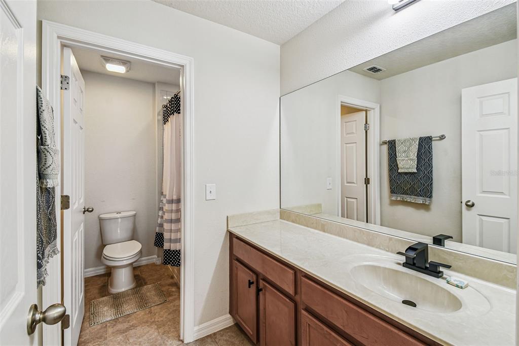 10624 Reams Road Windermere, FL 34786 - Photo 32 of 61 a bathroom with a sink a toilet and a large mirror