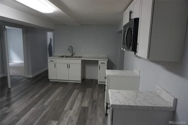 a kitchen with white cabinets stainless steel appliances and sink