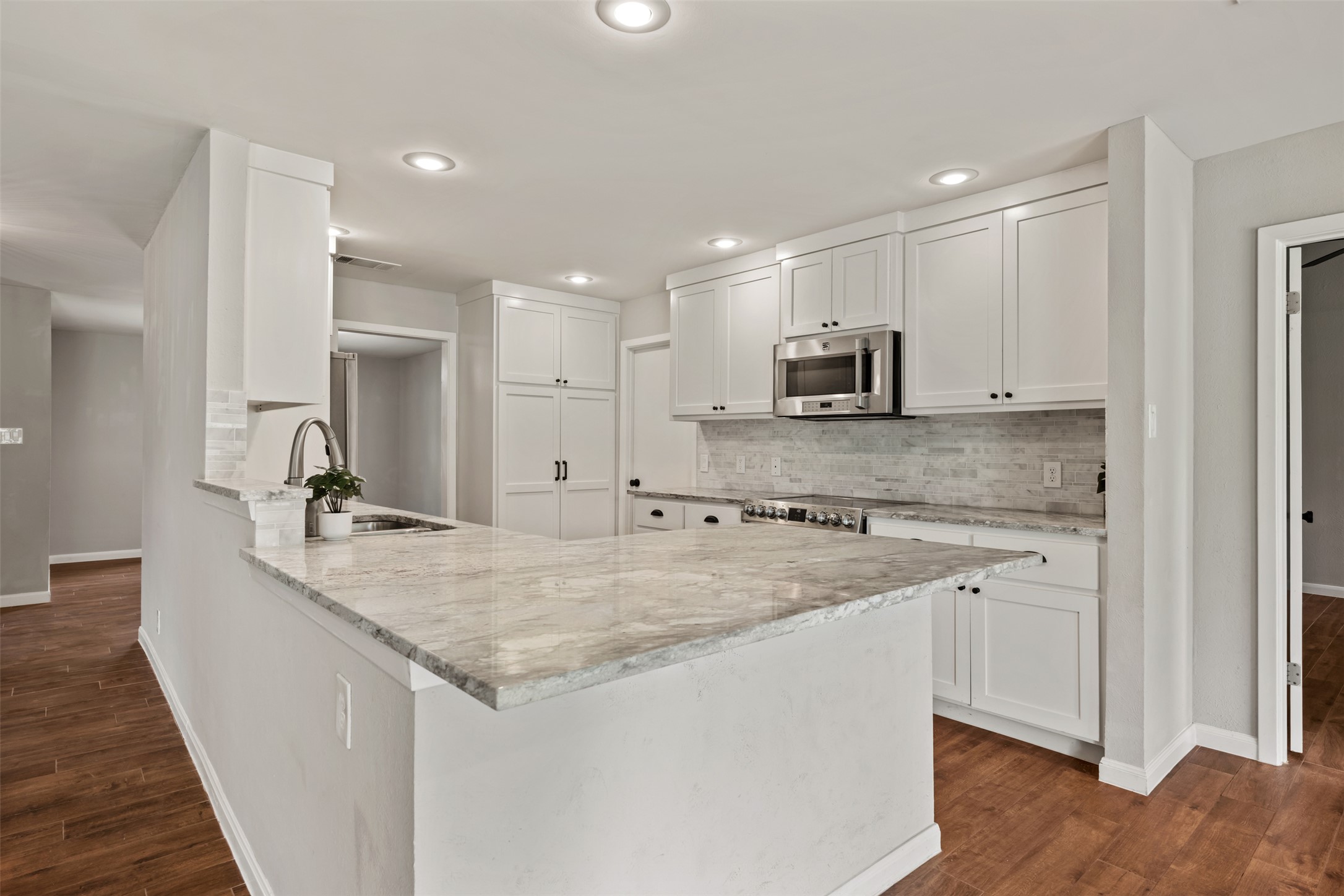 1600 Pin Oak Lane Round Rock, TX 78681 - Photo 16 of 40 Kitchen featuring a central island with an undermount sink and a gooseneck faucet