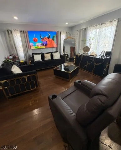 a living room with furniture a flat screen tv and a large window